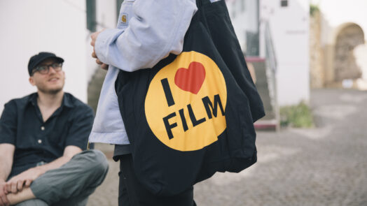Mensch mit Tasche mit Aufdruck I Love Film
