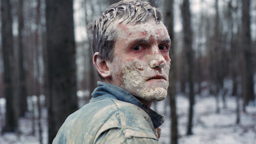 Still aus WINTER BROTHERS von Hlynur Pálmason, Mann im Wald mit weißem Dreck im Gesicht