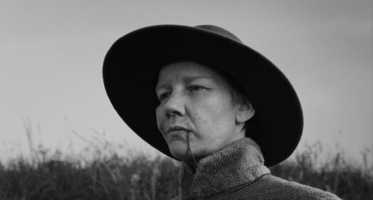 Sandra Hüller in sw mit Hut und Kette im Mund